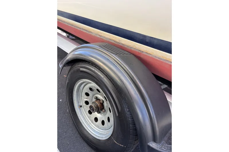 Slide: The Image of Close-up of a 2014 Tattoo 26 trailer wheel and fender, showcasing tire details. - 26