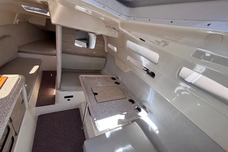 Slide: The Image of Interior of a 2014 Tattoo 26 sailboat, featuring a compact dining area and cozy sleeping quarters. - 8