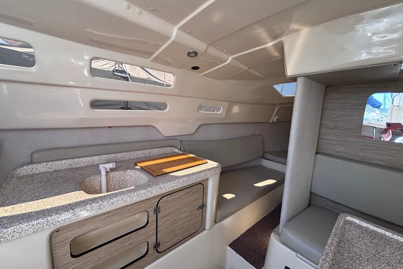 Slide: The Image of Interior of a 2014 Tattoo 26 sailboat featuring a compact kitchenette and seating area. - 6