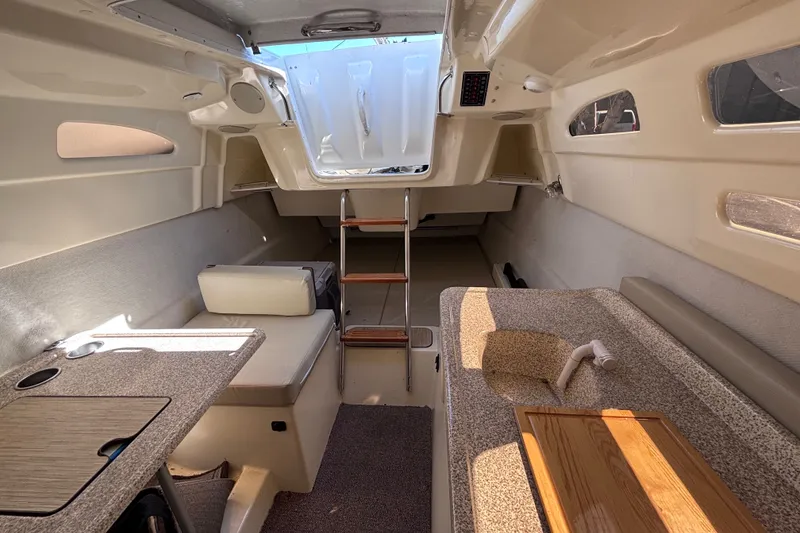 Slide: The Image of Interior of a 2014 Tattoo 26 sailboat featuring a compact kitchen and seating area. - 7