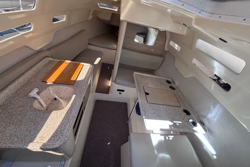 Slide: The Image of Interior of a 2014 Tattoo 26 sailboat, featuring seating and compact tables. - 5