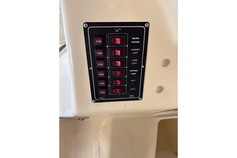 Slide: The Image of Control panel with switches for water system, lights, and auxiliary functions on a Tattoo 26 boat. - 19