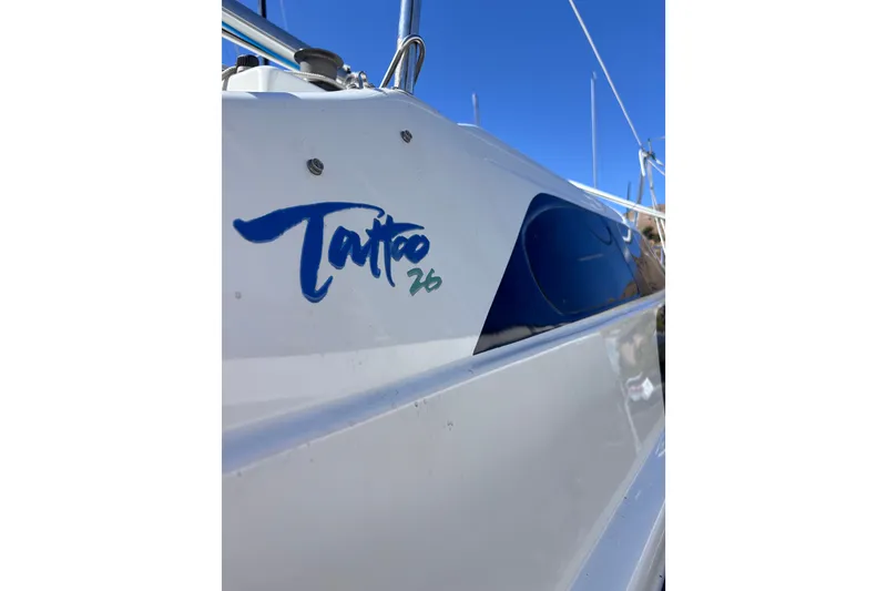 Slide: The Image of Close-up of a 2014 Tattoo 26 sailboat with blue logo under clear sky. - 4