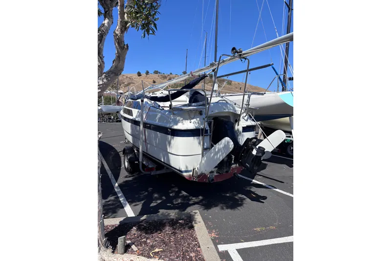 Slide: The Image of 2014 Tattoo 26 sailboat on trailer in parking lot, clear blue sky background. - 18