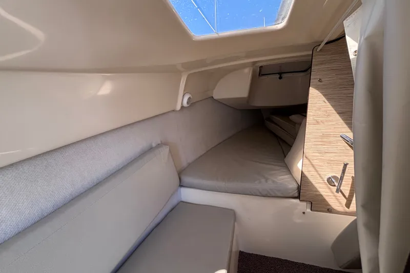 Slide: The Image of Interior cabin of a 2014 Tattoo 26 sailboat with beige cushions and wooden accents. - 9