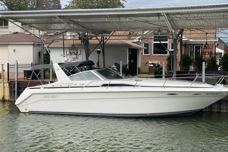 The Image of 1990 Sea Ray Sundancer 350 docked at a marina, showcasing sleek design and classic style. - 0