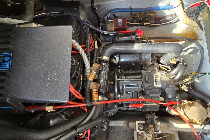 Slide: The Image of Engine compartment of a 1990 Sea Ray Sundancer 350, showcasing mechanical components and wiring. - 28
