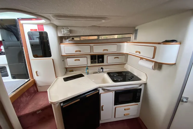 Slide: The Image of Interior of a 1990 Sea Ray Sundancer 350 yacht kitchen with modern amenities. - 16