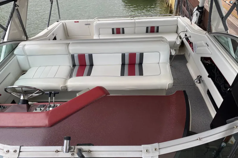 Slide: The Image of 1990 Sea Ray Sundancer 350 boat interior with white seating and red accents. - 14