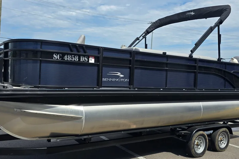 Slide: The Image of 2022 Bennington SX 22 Fishing pontoon boat on trailer, side view. - 2