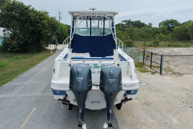 Slide: The Image of A 2014 Robalo R305 Walkaround with twin outboard engines, parked on a trailer. - 12