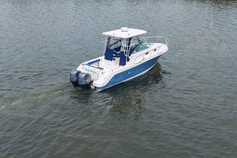 Slide: The Image of 2014 Robalo R305 Walkaround boat cruising on calm water. - 20