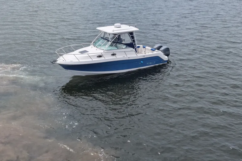 The Image of 2014 Robalo R305 Walkaround boat cruising on open water. - 15