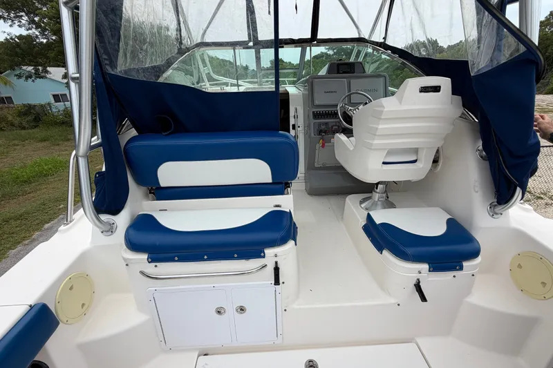 Slide: The Image of 2014 Robalo R305 Walkaround boat interior with blue and white seating and steering console. - 32