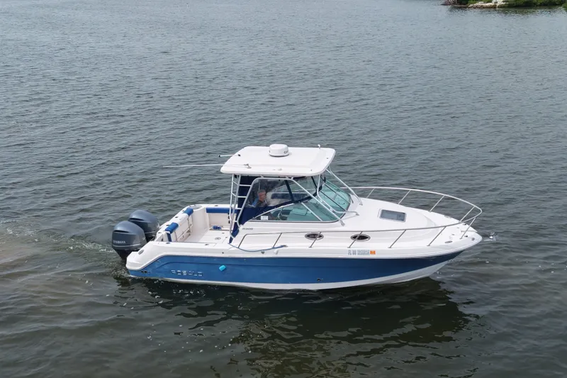Slide: The Image of 2014 Robalo R305 Walkaround boat cruising on calm waters. - 19
