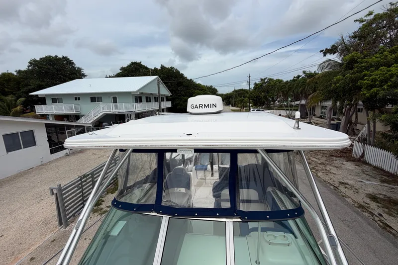 Slide: The Image of 2014 Robalo R305 Walkaround boat with Garmin radar, parked near residential area. - 43
