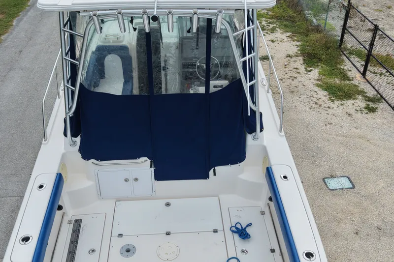 Slide: The Image of 2014 Robalo R305 Walkaround boat deck with blue seating and covered helm. - 13