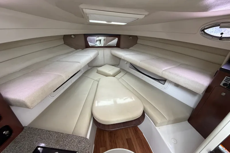Slide: The Image of 2014 Robalo R305 Walkaround cabin interior with beige seating and wood accents. - 25