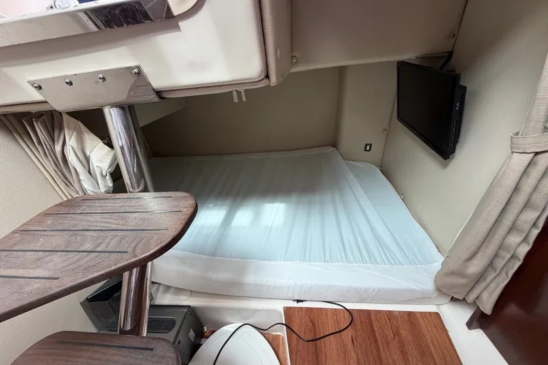 Slide: The Image of 2014 Robalo R305 Walkaround cabin interior with bed and mounted TV. - 24