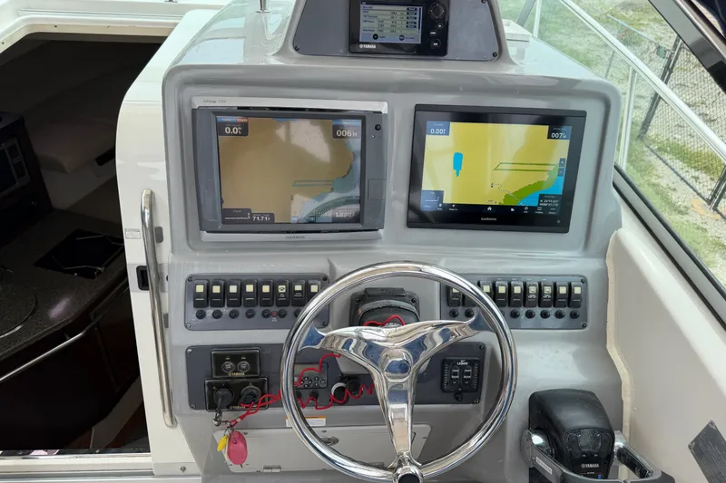 Slide: The Image of 2014 Robalo R305 Walkaround helm with dual Garmin displays and steering wheel. - 29