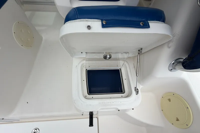 Slide: The Image of 2014 Robalo R305 Walkaround boat storage compartment with blue seating and white interior. - 33