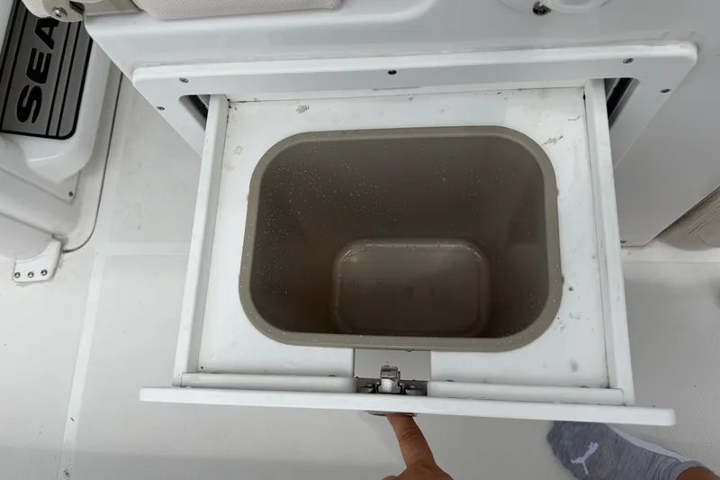 Slide: The Image of Open storage compartment on 2026 Sea Hunt Ultra 265SE boat, featuring a built-in container. - 4