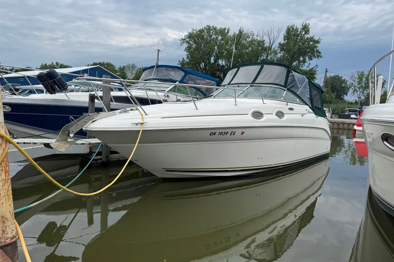 The Image of 2002 Sea Ray Sundancer 260 docked in a marina, surrounded by other boats. - 0