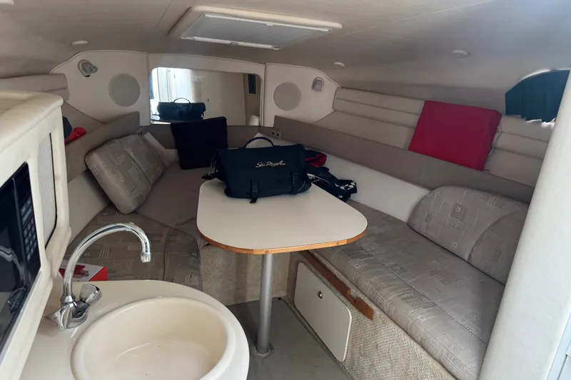 Slide: The Image of Interior of 2002 Sea Ray Sundancer 260 boat with seating, table, and kitchenette. - 26