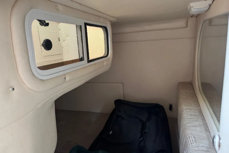 Slide: The Image of Interior cabin of a 2002 Sea Ray Sundancer 260 boat, featuring a window and seating area. - 22