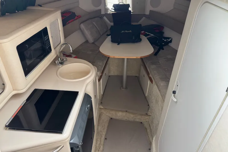 Slide: The Image of Interior of 2002 Sea Ray Sundancer 260 with kitchenette and seating area. - 18