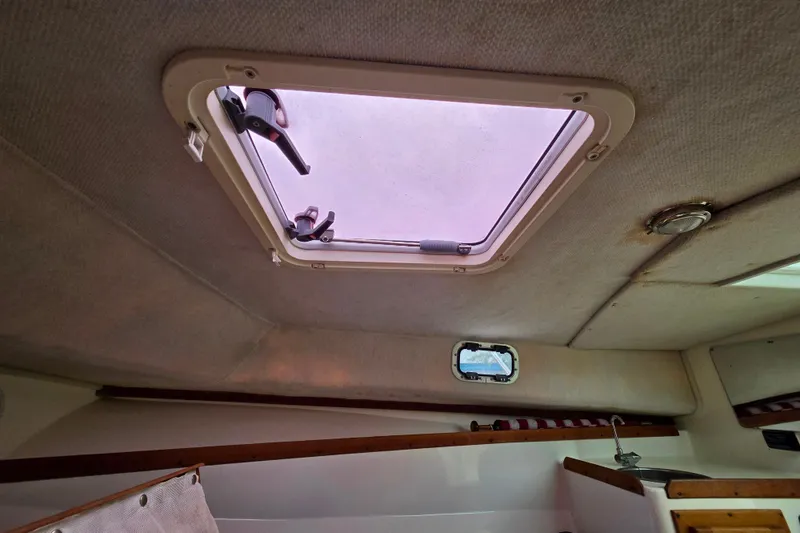 Slide: The Image of 2004 Hunt Yachts Surfhunter 25 cabin interior with hatch and porthole. - 23