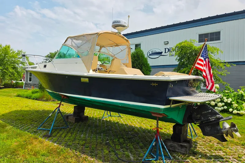 Slide: The Image of 2004 Hunt Yachts Surfhunter 25 on stands, with American flag, outside a building. - 3