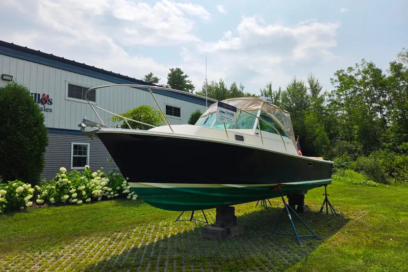 Slide: The Image of 2004 Hunt Yachts Surfhunter 25 on display outdoors near a sales building. - 5
