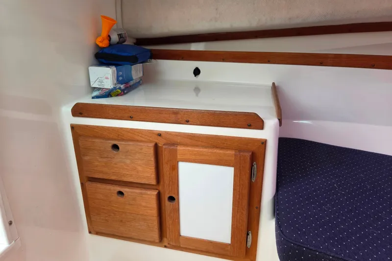 Slide: The Image of 2004 Hunt Yachts Surfhunter 25 cabin with wooden storage and seating area. - 31