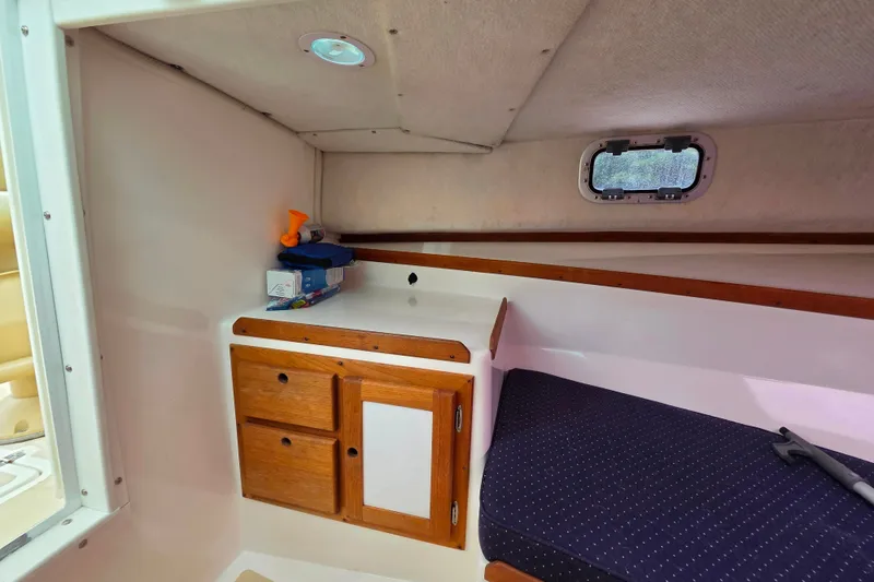 Slide: The Image of Interior cabin of 2004 Hunt Yachts Surfhunter 25 with wooden storage and seating. - 30