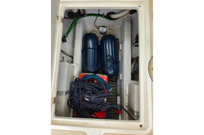 Slide: The Image of 2004 Hunt Yachts Surfhunter 25 storage compartment with ropes and fenders. - 20