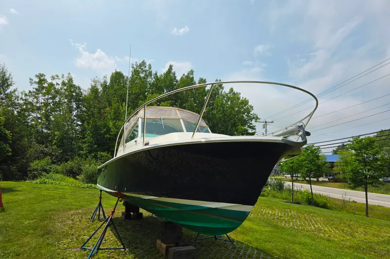 Slide: The Image of 2004 Hunt Yachts Surfhunter 25 on land, surrounded by trees and clear sky. - 6