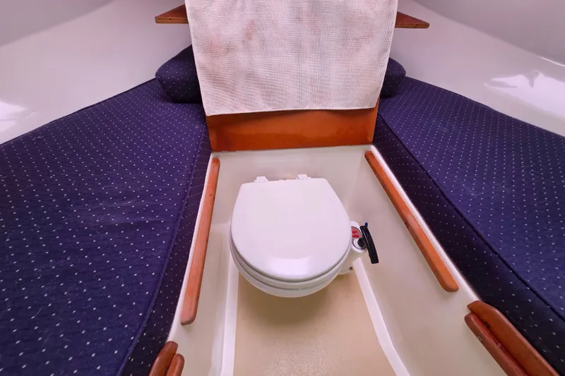 Slide: The Image of 2004 Hunt Yachts Surfhunter 25 cabin interior with toilet and blue cushioned seating. - 25