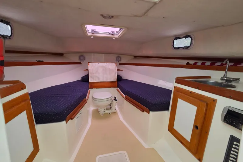 Slide: The Image of 2004 Hunt Yachts Surfhunter 25 cabin interior with seating, sink, and toilet. - 21