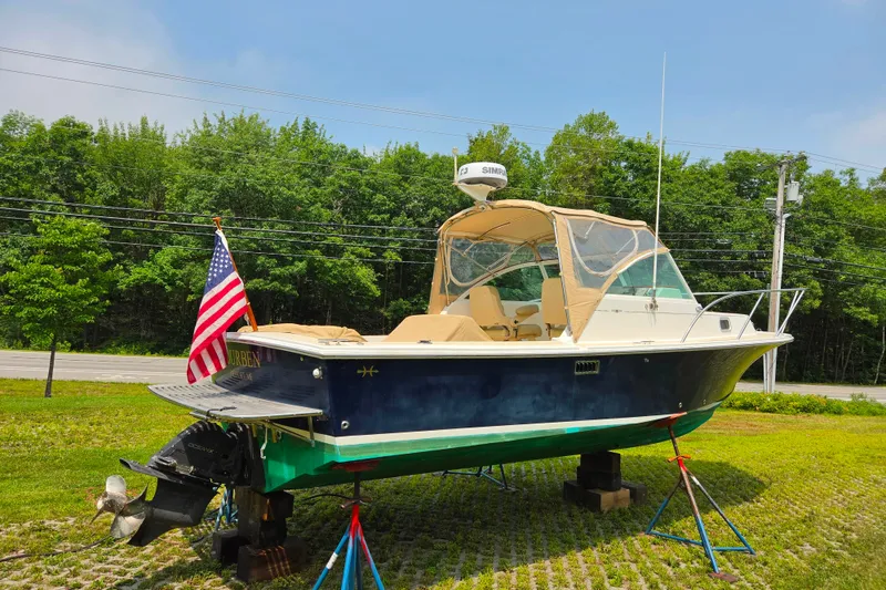 Slide: The Image of 2004 Hunt Yachts Surfhunter 25 on stands, American flag, lush green background. - 1