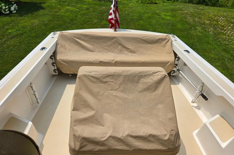 Slide: The Image of 2004 Hunt Yachts Surfhunter 25 deck with beige covers and American flag. - 7