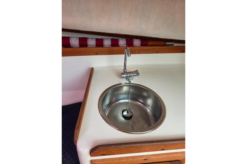 Slide: The Image of 2004 Hunt Yachts Surfhunter 25 interior sink with faucet and wooden trim. - 33