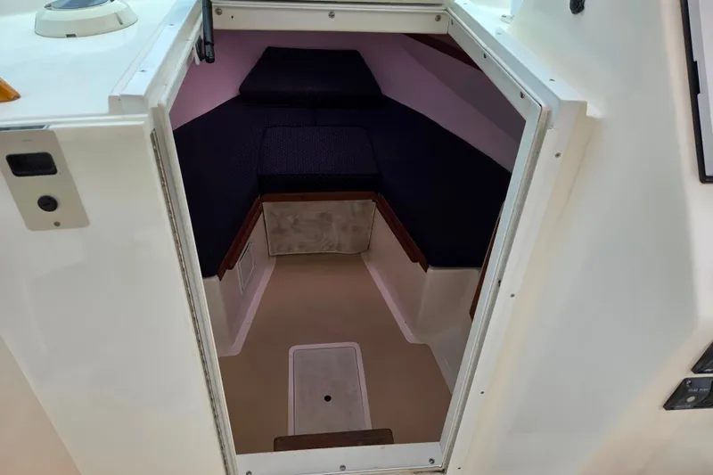 Slide: The Image of 2004 Hunt Yachts Surfhunter 25 cabin interior with cushioned seating and compact design. - 13