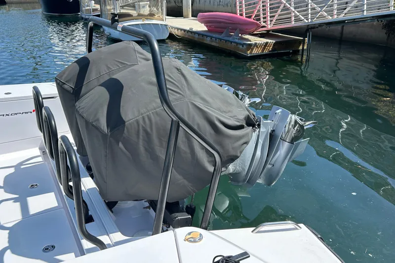 Slide: The Image of 2024 Axopar 37 XC Cross Cabin with covered outboard motors docked by the water. - 6