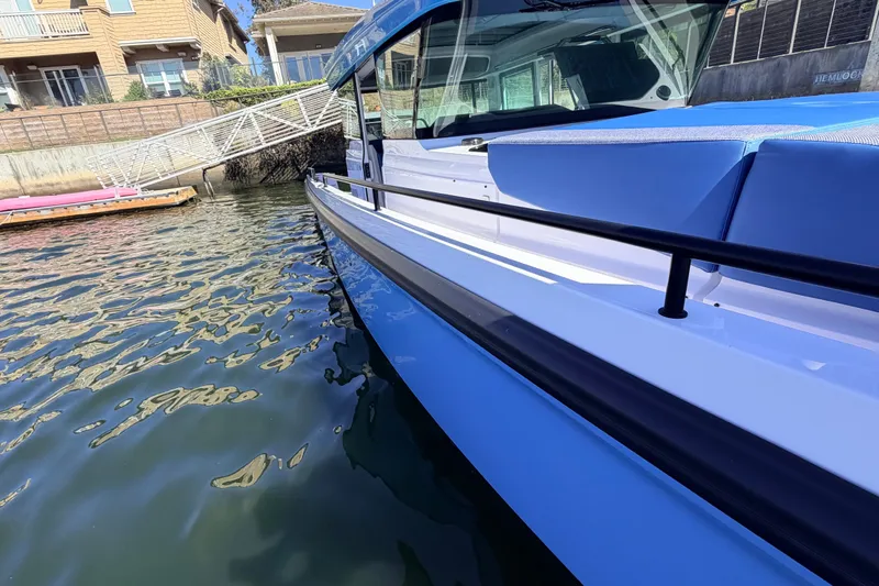 Slide: The Image of 2024 Axopar 37 XC Cross Cabin boat docked by waterfront homes. - 13