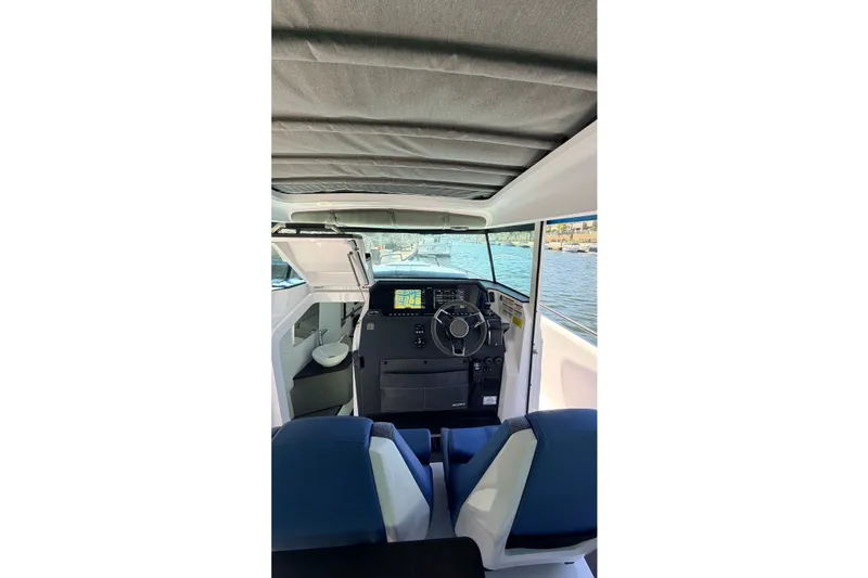 Slide: The Image of Interior view of 2024 Axopar 37 XC Cross Cabin boat, featuring helm and seating. - 24