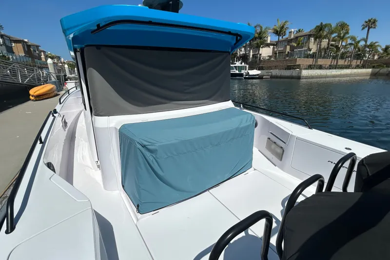 Slide: The Image of 2024 Axopar 37 XC Cross Cabin boat docked, featuring a blue canopy and covered seating area. - 3