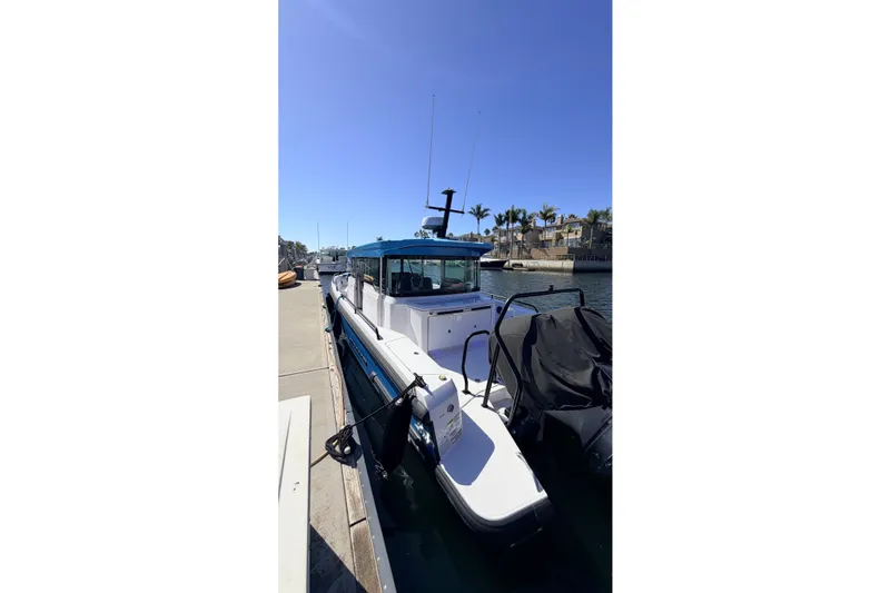Slide: The Image of 2024 Axopar 37 XC Cross Cabin docked by the waterfront under clear blue skies. - 18