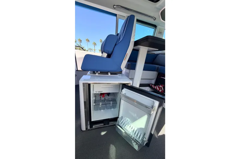 Slide: The Image of Interior of 2024 Axopar 37 XC Cross Cabin with open mini fridge under blue seat. - 22