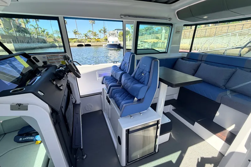 Slide: The Image of 2024 Axopar 37 XC Cross Cabin interior with blue seating and modern helm. - 20